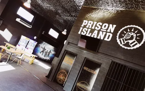 L'espace de jeu de Prison Island Montpellier, ses portes de cellules alignées sous une lumière tamisée